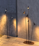 Two clusters lit on paving against a textured render garden wall