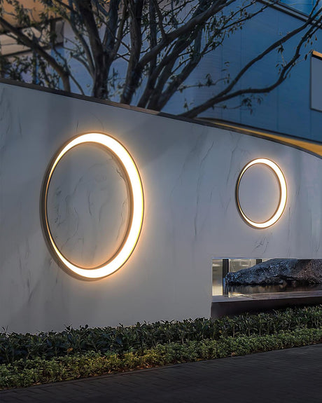 Two rings of different sizes lit on a long garden wall above low plants
