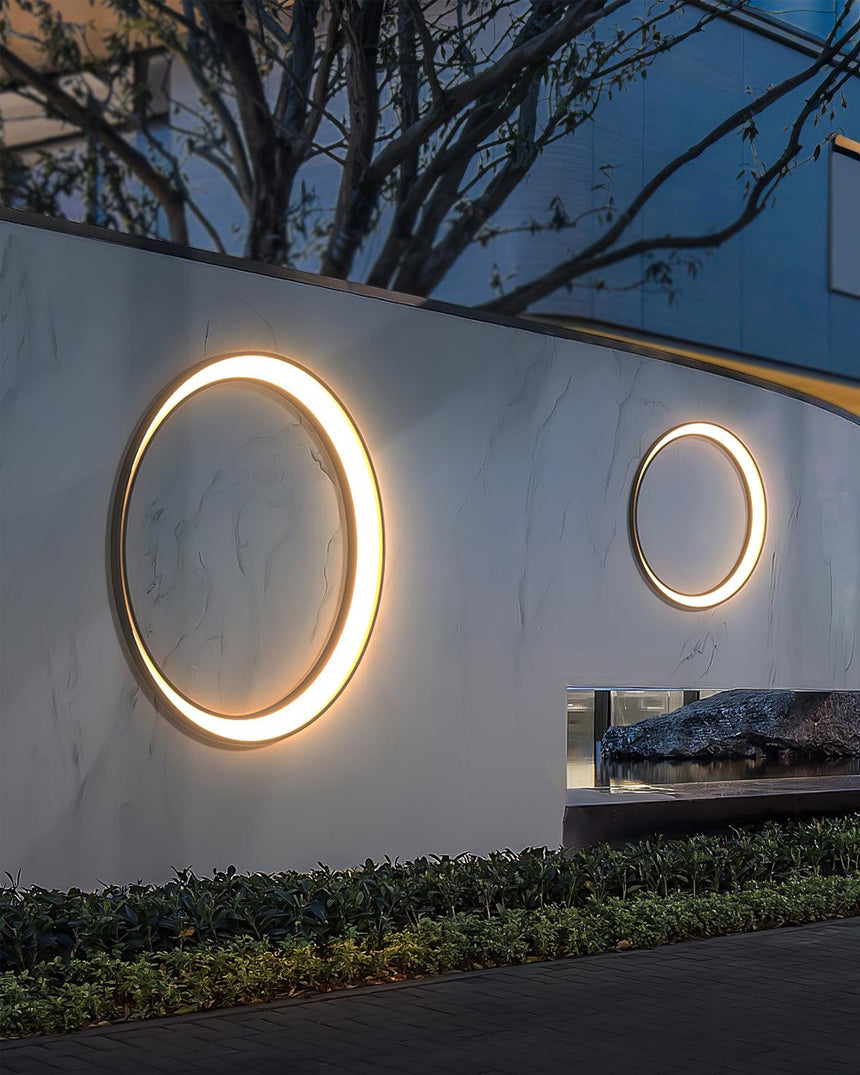 Two rings of different sizes lit on a long garden wall above low plants