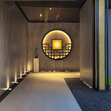 The round light at the end of a covered corridor above a pale stone path
