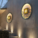 Two round lattice lights on a gray garden wall above stone steps lit by small uplights