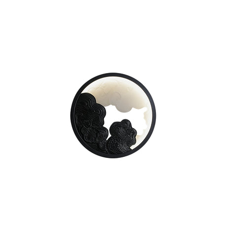 The black relief version, the lit disc bright behind the dark layers