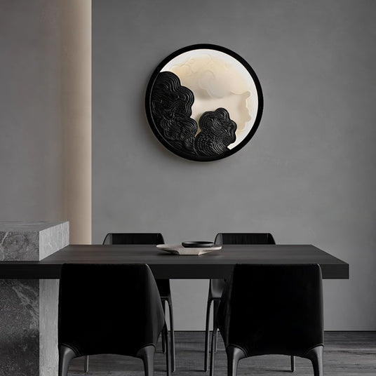 Sconce lit on a dining room wall above a dark table with four chairs