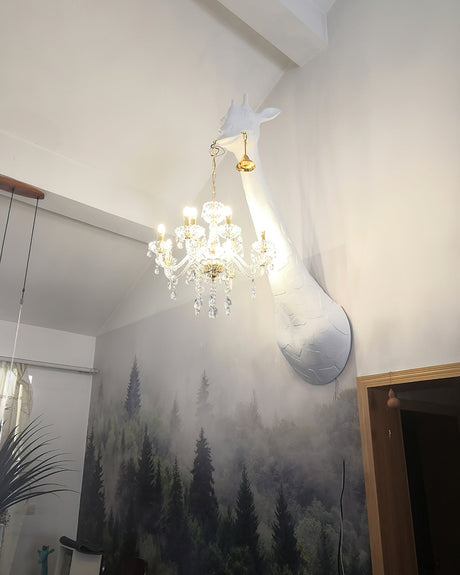 The giraffe lamp high on the wall of a large room beside a forest mural
