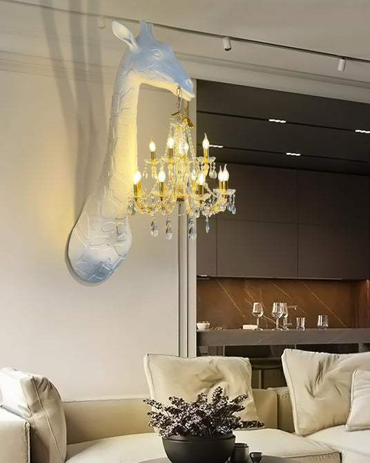 The giraffe lamp lit above a cream sofa in an open living room with a kitchen behind