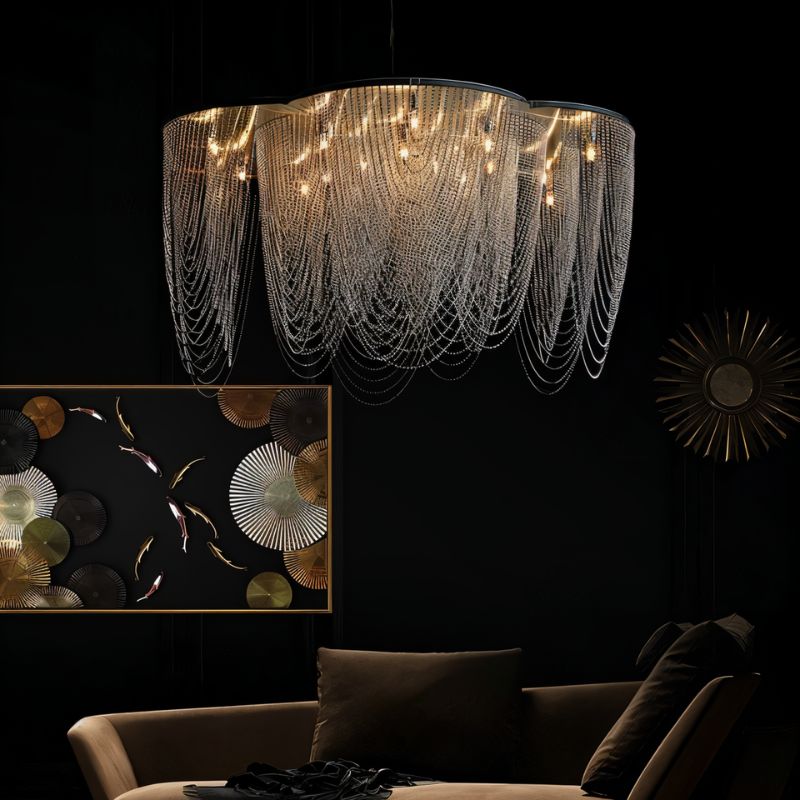 The fitting lit in a dark room above a brown sofa beside a sunburst mirror