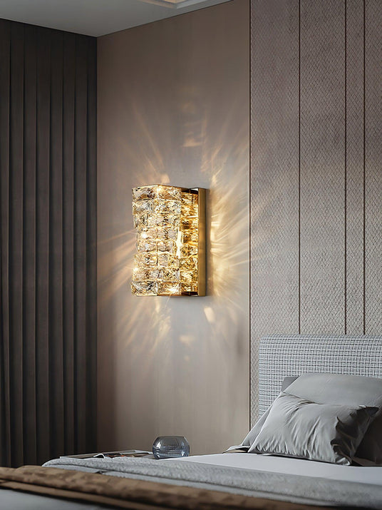 The gold version lit above a bed with a gray headboard, rays of light on the wall