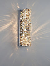 The chrome version lit on a pale wall, the blocks sparkling