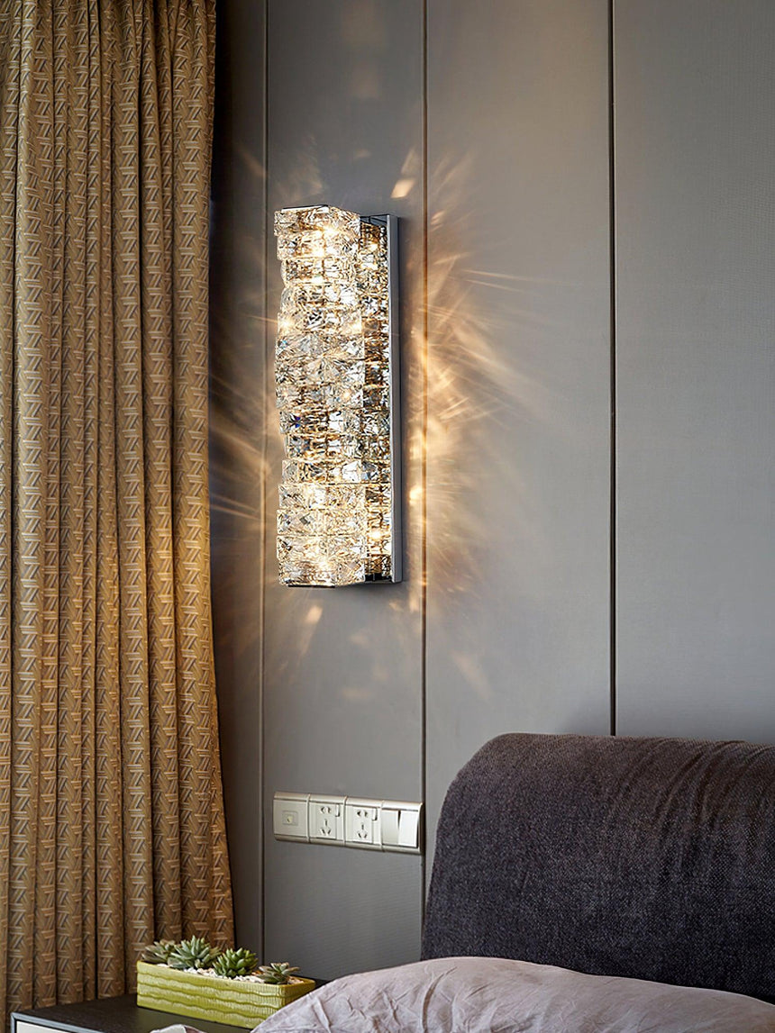 The chrome version lit beside a brown curtain above a gray headboard