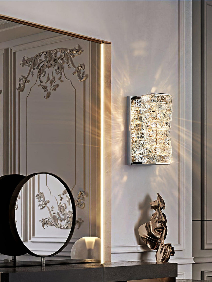 The chrome version beside a round mirror above a console with a sculpture