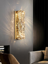 The gold version lit on a gray wall above the arm of a sofa