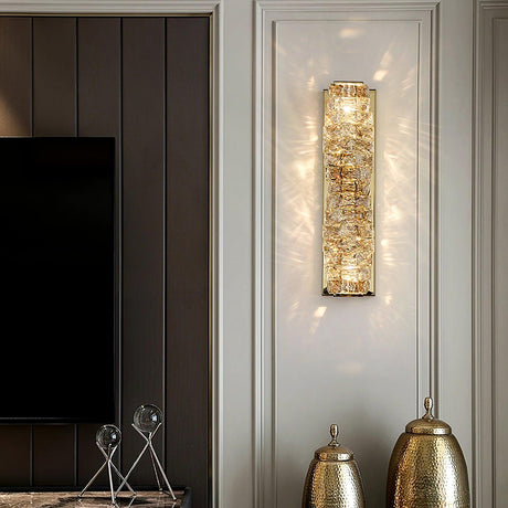 The gold version lit on a paneled wall beside a TV and two tall vases in a living room