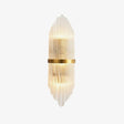 Tall wall sconce of clear crystal rods around a brass band, lit up and down