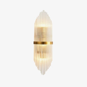 Tall wall sconce of clear crystal rods around a brass band, lit up and down