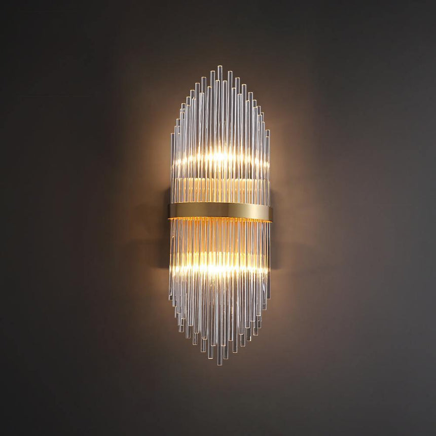 The sconce lit on a dark wall, the rods catching the light