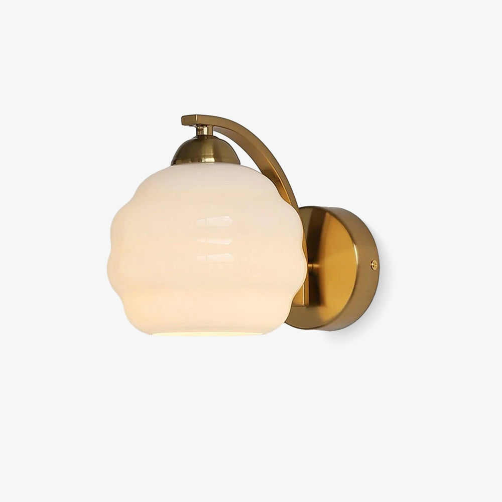 Wall sconce with a curved gold arm holding a white ribbed glass globe