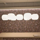 A row of opal glass balls lit above a banquette with a patterned wall