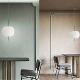 Two opal glass balls lit beside a doorway in a green painted room