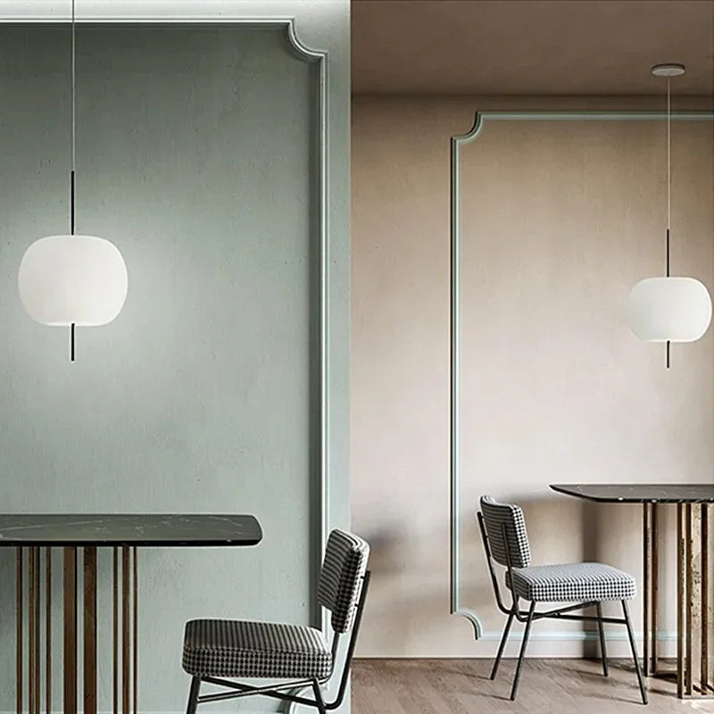 Two opal glass balls lit beside a doorway in a green painted room