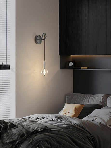 The crystal ball lit beside a window above a bed with gray bedding