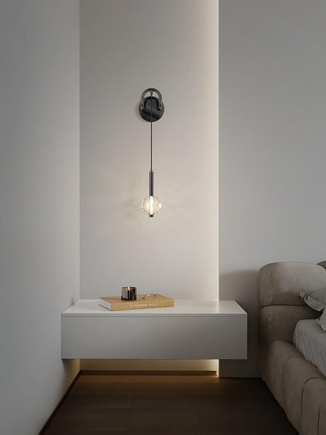 The crystal ball lit above a floating white nightstand with a book