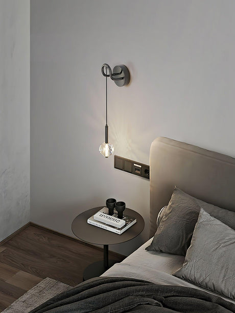 The crystal ball lit beside a gray headboard above a round side table