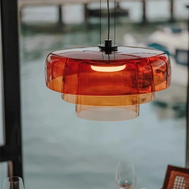 Glass ceiling light in stacked orange discs beside a window