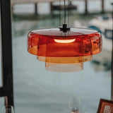 Glass ceiling light in stacked orange discs beside a window