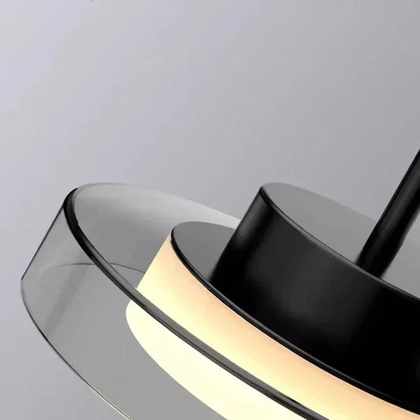 Close view of two lit discs showing the opal ring held inside the clear glass