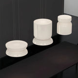 Group of jade glass shades lit together above a dark surface
