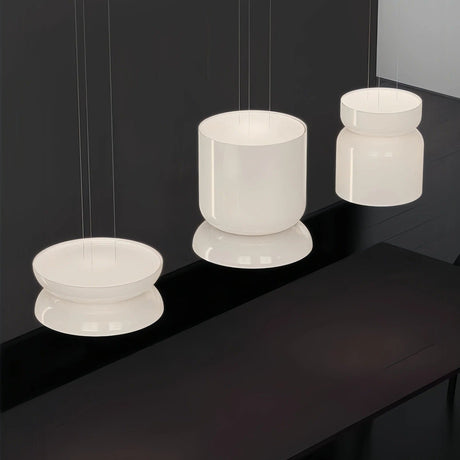 Group of jade glass shades lit together above a dark surface