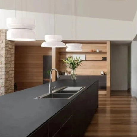 Pair of white glass pendants above a kitchen island and sink