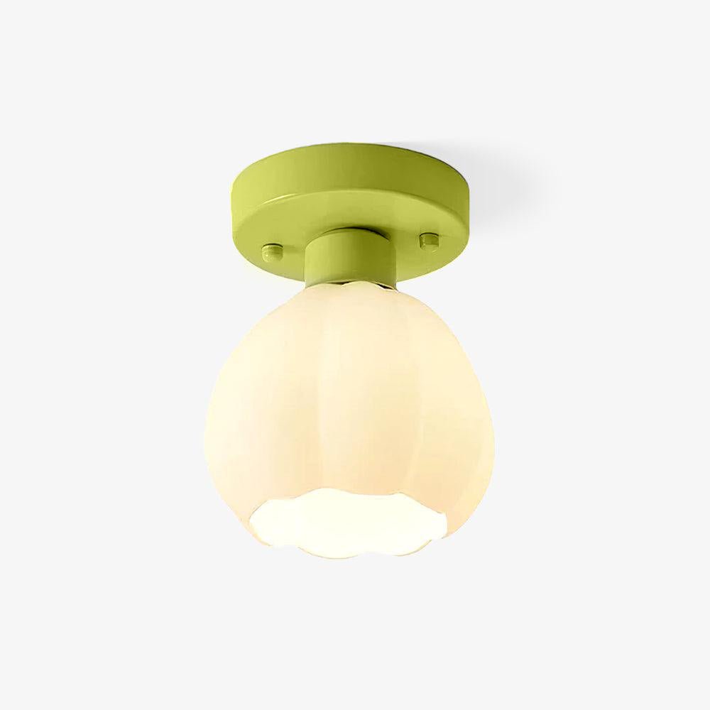 Glass semi flush mount ceiling light with a white flower shade on a green base