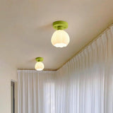 Two flower shade ceiling lights lit along a hallway ceiling beside curtains