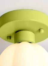 Close view of the green metal canopy and the top of the white glass shade