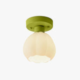 Flower shade semi flush ceiling light lit, shown against a plain background