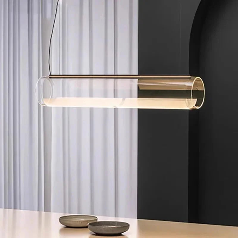 The tube lit above a low table in front of a long pale curtain