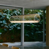 The lit tube seen against a window with a green garden behind it