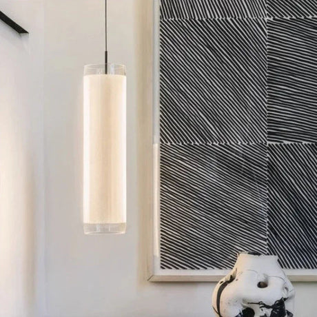 The vertical tube hung beside a textured wall panel above a small table