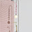 The pink glass chain and lit globe beside a pink window blind, a vase of flowers below