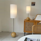 Globe table lamp on a sideboard beside a matching tall floor version