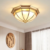 Faceted brass dome ceiling light in a bedroom with sheer curtains
