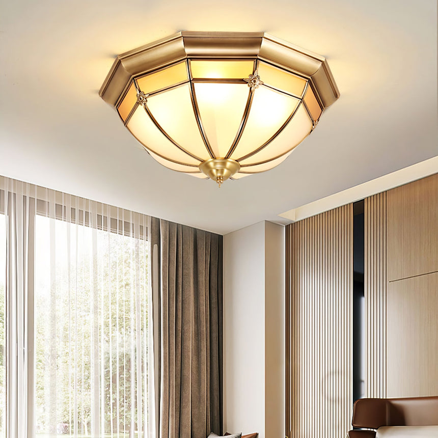 Faceted brass dome ceiling light in a bedroom with slatted curtains