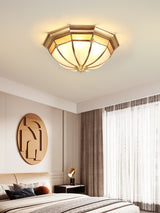 Faceted brass dome ceiling light in a bedroom with a round wall art piece