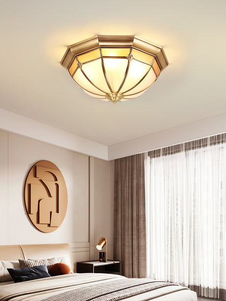 Faceted brass dome ceiling light in a bedroom with a round wall art piece