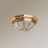 Faceted brass dome ceiling light seen at an angle on a pale backdrop