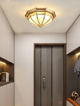 Faceted brass dome ceiling light near a doorway in a corridor