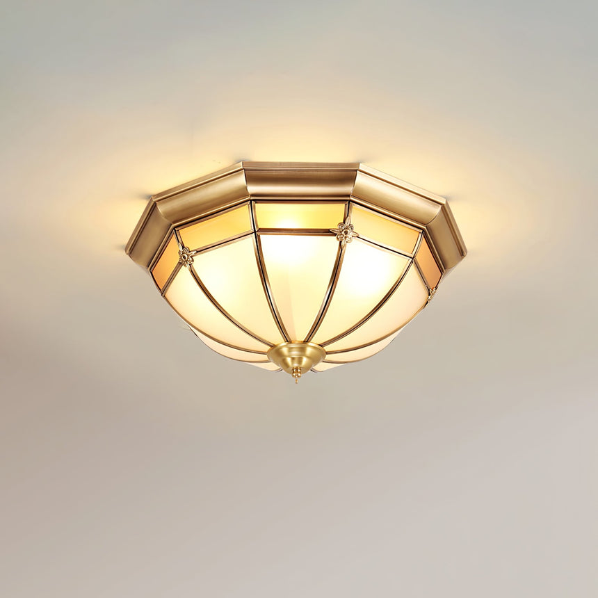 Faceted brass dome ceiling light lit against a plain ceiling