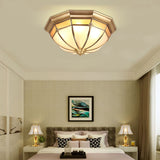 Faceted brass dome ceiling light above a bed with two table lamps