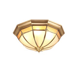 Faceted brass dome ceiling light shown unlit on a white backdrop